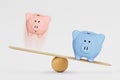 Pink and blue piggy bank on balance scale - Gender pay gap concept