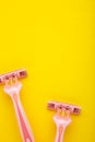 Pink and blue razors on yellow background close up Royalty Free Stock Photo