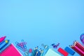 Pink and blue school supplies bottom border over a pastel blue background Royalty Free Stock Photo