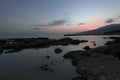 Pink and blue sunset on the beach in Creta, Greece. Beach with blacks rocks and waves at dusk Royalty Free Stock Photo