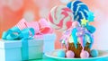 Pink and blue novelty cupcake decorated with candy and large lollipops.