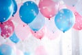 Pink, blue and white balloons, confetti and streamers as a decorations at a gender reveal or a baby shower party Royalty Free Stock Photo