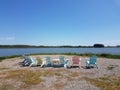 Pink, Blue and Yellow Deck chairs on a Lake shore Royalty Free Stock Photo