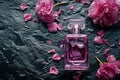 Pink bottle of perfume on background of black wet stone and flowers Royalty Free Stock Photo