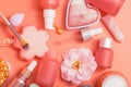 Cosmetic products. Pink bottles and tubes with dispensers, pipette, heart-shaped blush, brushes, cream, essence