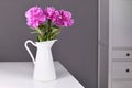 Pink bouquet of Chinese peony flowers in white vase on table Royalty Free Stock Photo