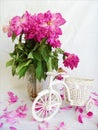pink bouquet of withered pion flowers and decorative bicycle on white background