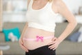 pink bow around mothers baby bump