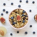 Pink bowl of fruit granola with fruits and honey, view from above. Flat lay, overhead, top view. Close-up