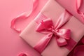 A pink box with a pink bow on top sits on a pink background Royalty Free Stock Photo