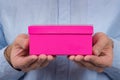 Pink box in mens hands. Man gives gift. Express delivery of gifts. Front view