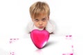 Pink box in a shape of heart with a child boy with a facial attitude ready to kiss someone Royalty Free Stock Photo