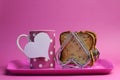 Pink breakfast tray with polka dot coffee tea cup mug and heart shape toast rack with wholemeal toast for Mothers Day, birthday or