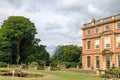 Pink brick historic mansion and park with art deco sculpture.