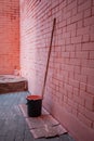 Pink brick wall. Paint roller for painting walls. Black bucket with paint. Repairs Royalty Free Stock Photo