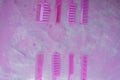 Pink bright comb for hairdressers. Beauty saloon. Tools for hairstyles. Pink background. Barbershop. Set of different hairbrushes