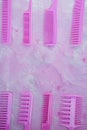 Pink bright comb for hairdressers. Beauty saloon. Tools for hairstyles. Pink background. Barbershop. Set of different hairbrushes