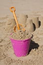 Pink bucket and orange spade in sand Royalty Free Stock Photo