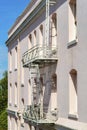 Pink building with gray metal fire escape ladder for emergencies or in case of fire with window cubies and trees and Royalty Free Stock Photo