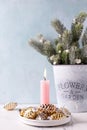 Pink burning candle, golden and silver decorative cones and branches of fir tree in bucket Royalty Free Stock Photo