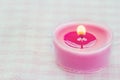 Pink burning candle on a romantic soft background