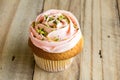 Pink cup cake on rustic wooden table close up Royalty Free Stock Photo