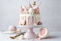 a pink cake with white frosting and toppings on a white table with a spoon and a plate with a piece of cake on it