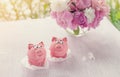 Pink cakes in the shape of little piggies with a bouquet of peonies for the holiday. Copy space.