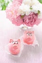 Pink cakes in the shape of pigs with a bouquet of peonies on the holiday. Copy the place.