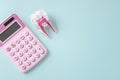 Pink calculator and tooth on blue background, top view