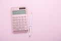 Pink calculator with white pen, flat lay