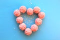 Pink candy on a blue and pink background folded in a heart with Royalty Free Stock Photo