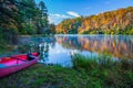 Pink canoe by colorful lake surrounded by fall colors in Smokey Mountains