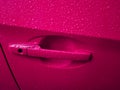 Pink car door handle with rain drops Royalty Free Stock Photo