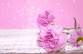 Pink Carnation flowers on rustic white wooden table.