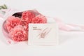 Pink carnations flower with card on white background.