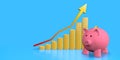 Pink ceramic piggy bank standing next to columns of gold coins forming economic growth graph with up arrow against blue background Royalty Free Stock Photo