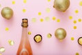 Pink champagne bottle with cork lid confetti and Christmas balls golden christmas decorations on pink background. Flat Royalty Free Stock Photo