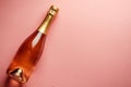 Pink champagne bottle on pastel background. Party background with sparkling wine, bubbling rose champagne, celebration concept. Royalty Free Stock Photo