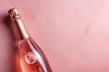 Pink champagne bottle on pastel background. Party background with sparkling wine, bubbling rose champagne, celebration concept. Royalty Free Stock Photo