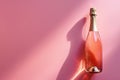 Pink champagne bottle on pastel background. Party background with sparkling wine, bubbling rose champagne, celebration concept. Royalty Free Stock Photo