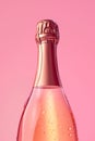 Pink champagne bottle on pastel background. Party background with sparkling wine, bubbling rose champagne, celebration concept. Royalty Free Stock Photo