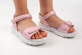 Pink children& x27;s sandals made of shiny leather with Velcro fasteners, flat white soles isolated on a white background. A