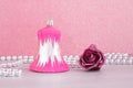 A pink christmas bell with a silver beaded garland and a purple rose Royalty Free Stock Photo