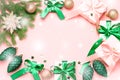 Pink Christmas card or New Year background, flat lay, copy space. Pastel pink gift boxes and green, golden decorations Royalty Free Stock Photo