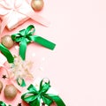 Pink Christmas card or New Year background, flat lay, copy space. Pastel pink gift boxes and green, golden decorations Royalty Free Stock Photo