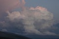 Pink cirro-cumulus and cumulus clouds in the evening light at sunset in the mountains