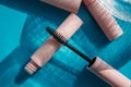 Pink clean makeup brush for mascara lies on the open tube, near to closed tubes of cosmetics, lip gloss, liquid lipstick