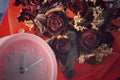 Pink clock and dried red roses Royalty Free Stock Photo