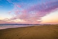 Pink clouds at sunset on the beach with Morro rock in the distance Royalty Free Stock Photo